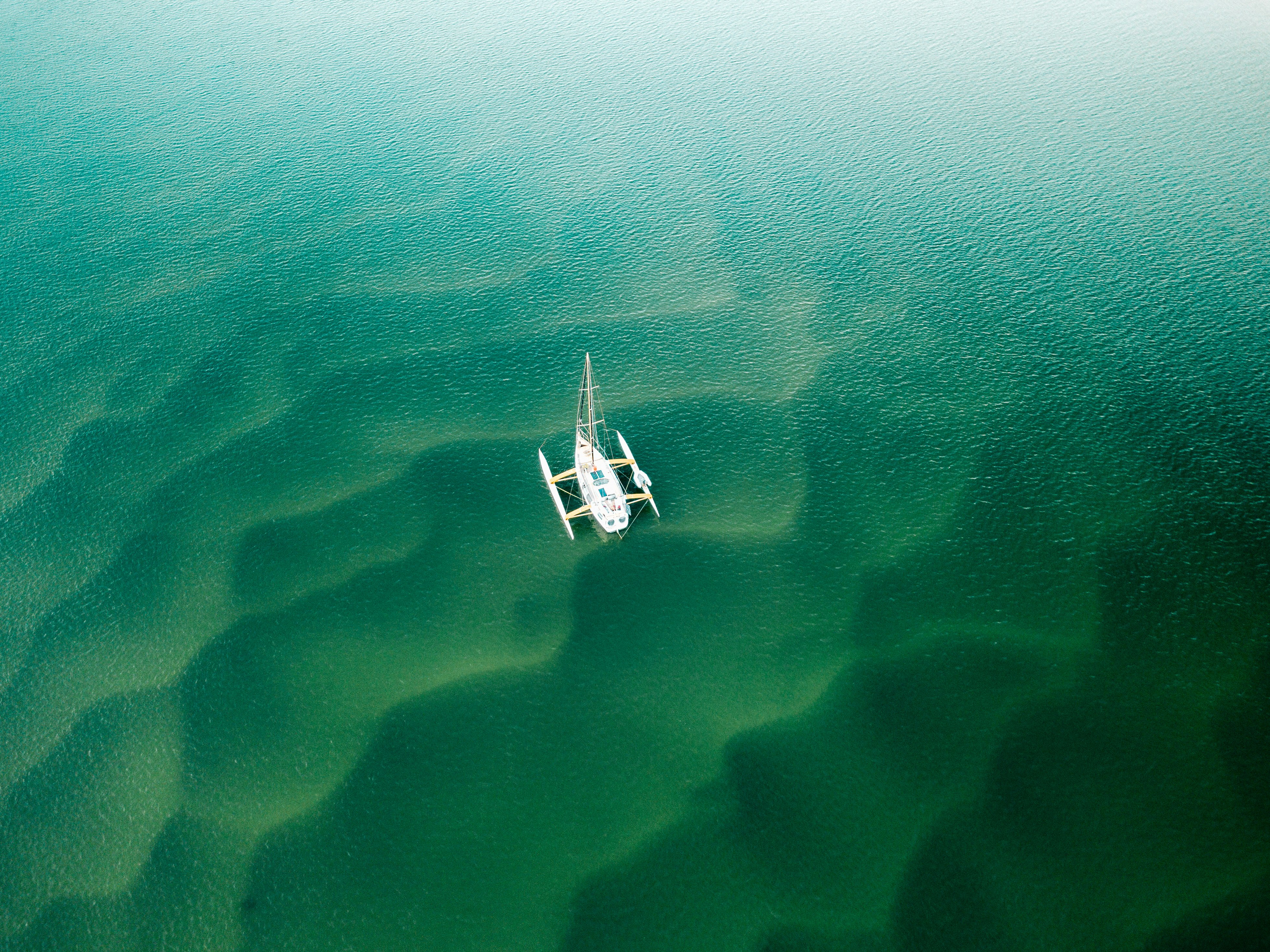 white boat on body of water at daytime